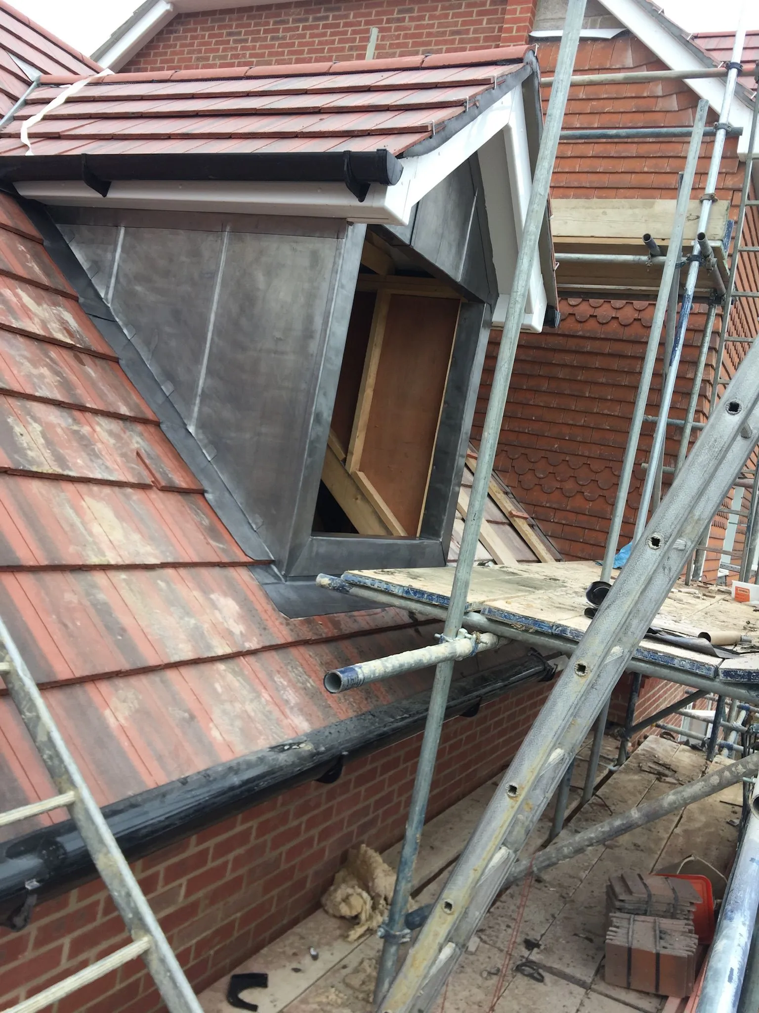 The roof of a house with scaffolding around it.
