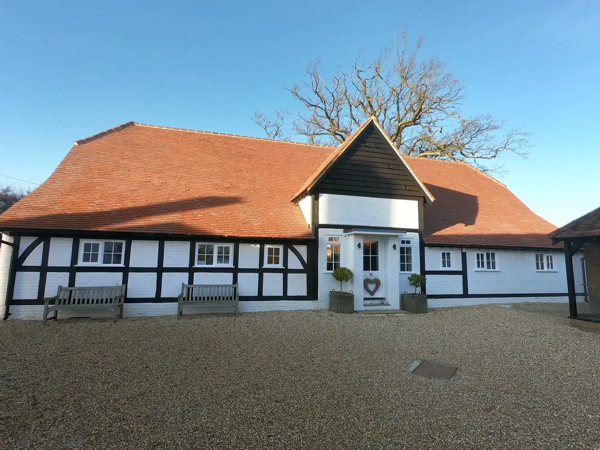A white and black house with a red roof.