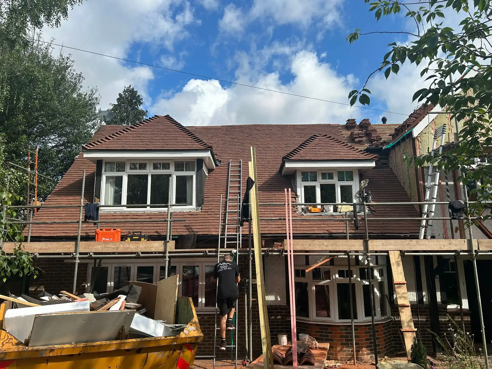 A house under construction with scaffolding on the roof.