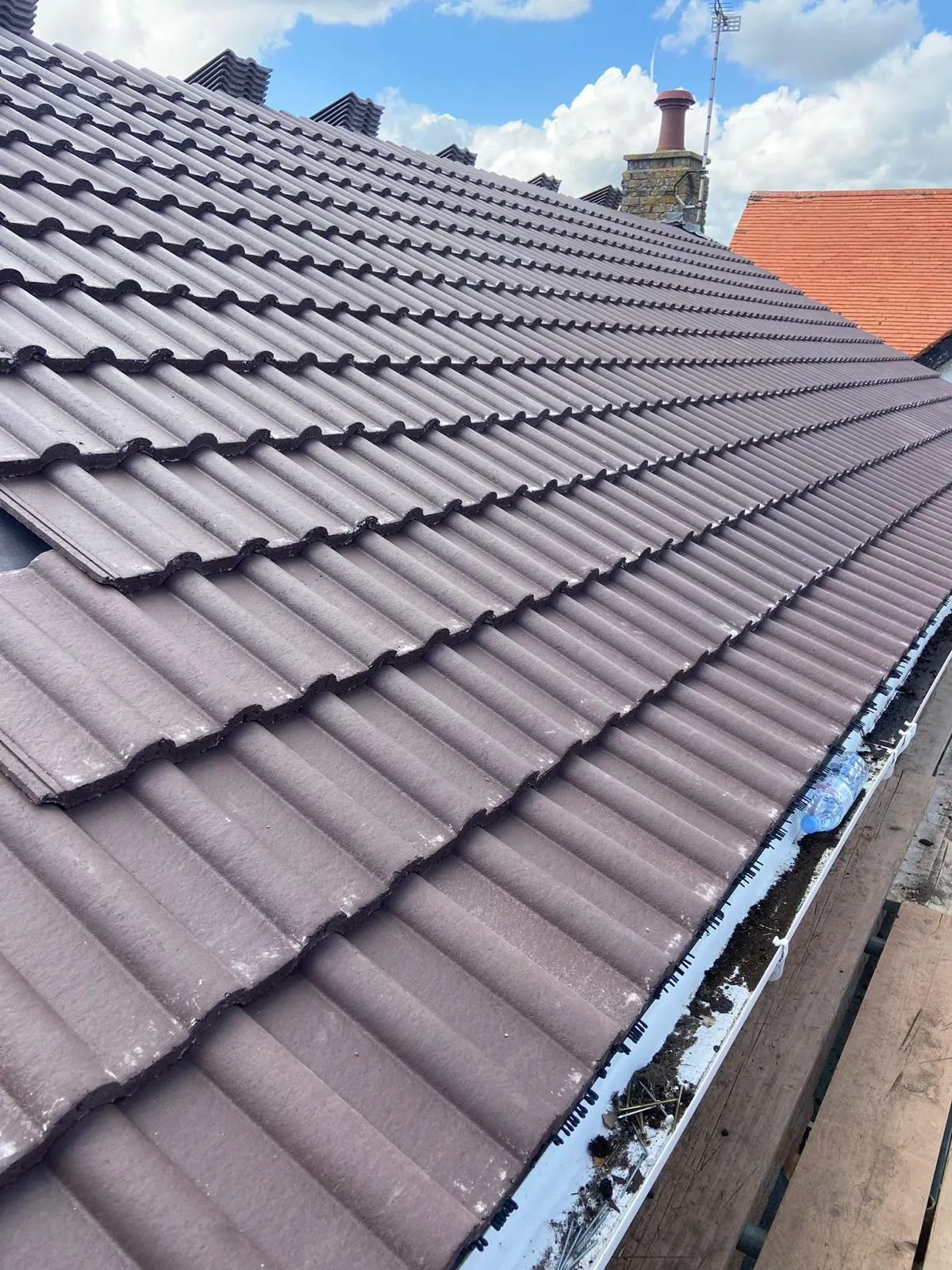 The roof of a house with a blue sky in the background.