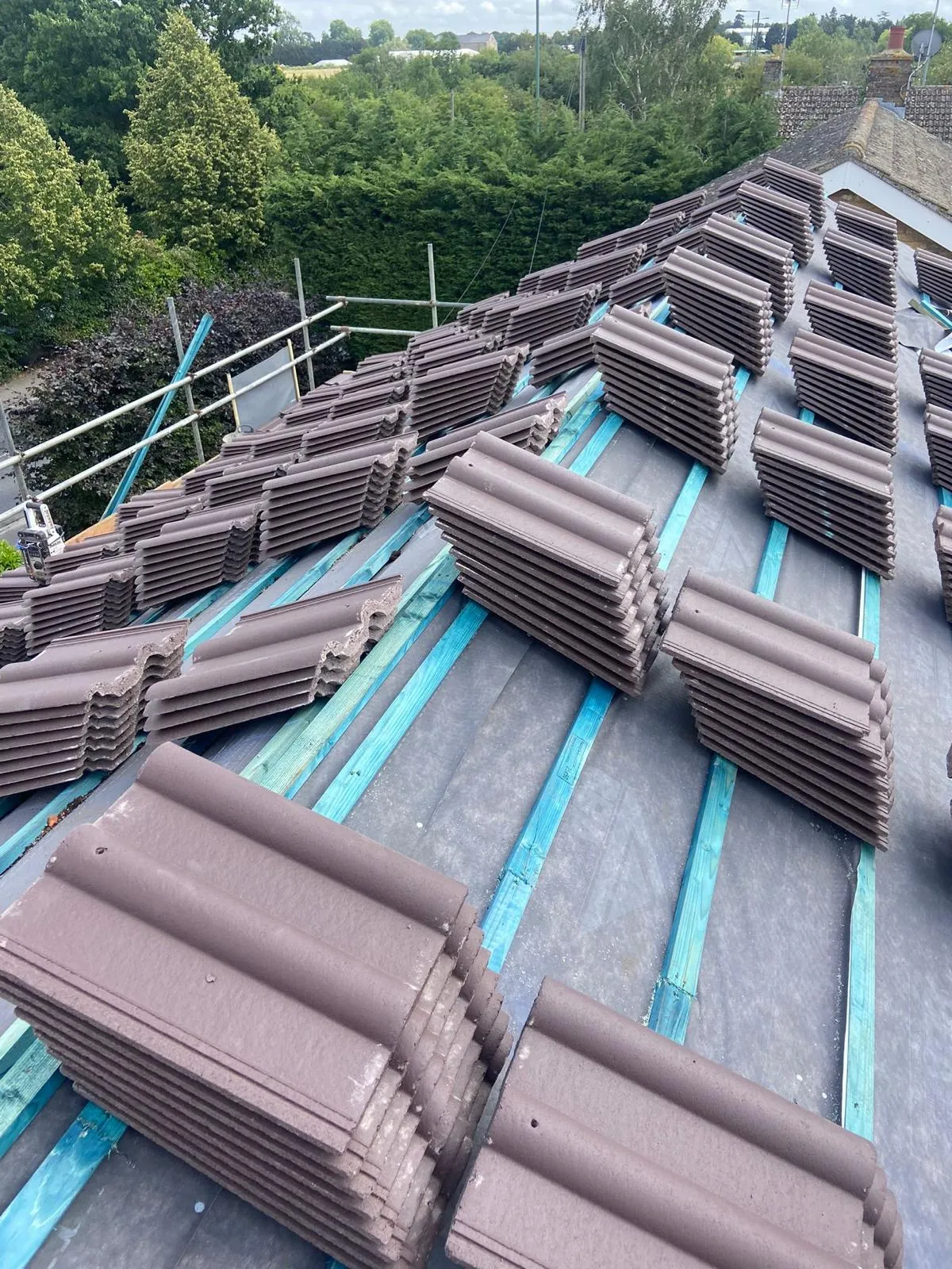 A large amount of brown roof tiles sitting on top of a building.