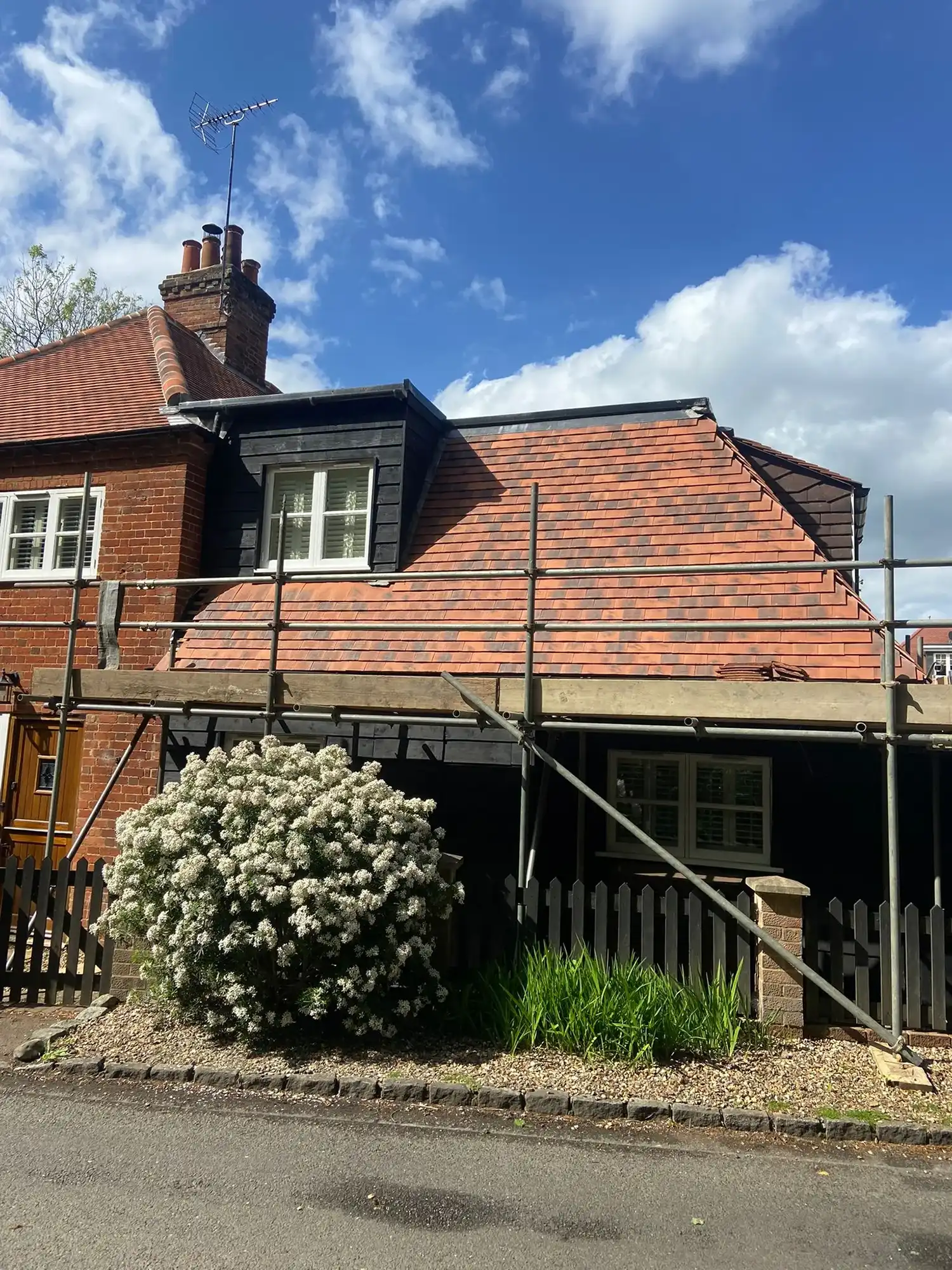 A house under construction with a red brick roof.